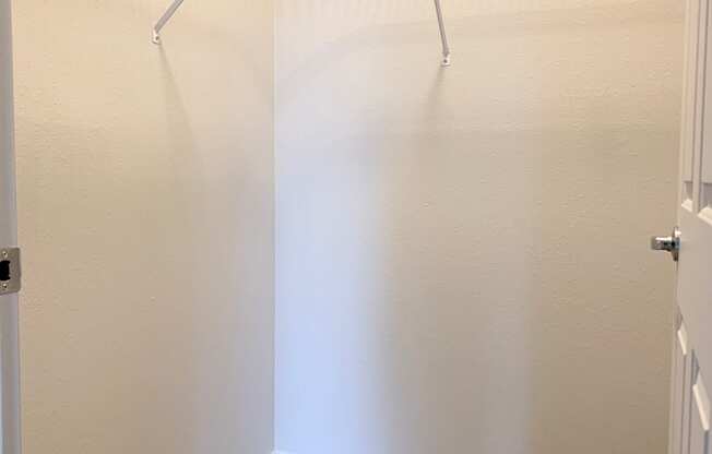 A white closet with a carpeted floor and a metal rack at Wilsonville Summit Apartments, Wilsonville  97070