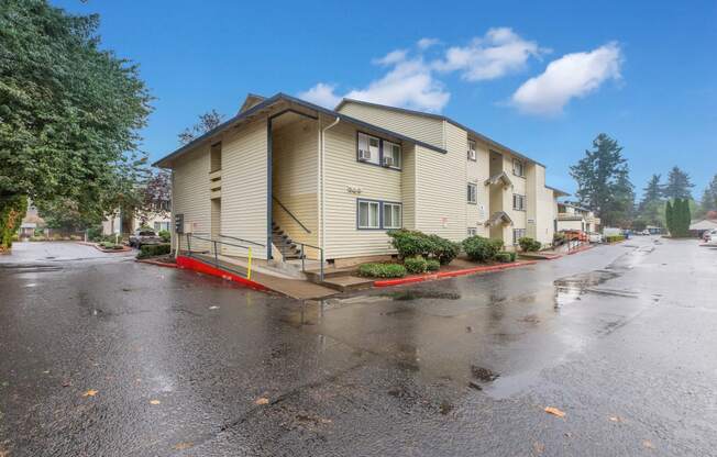 the view of an apartment building from the street in the rain