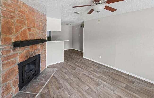A room with a fireplace and a ceiling fan.