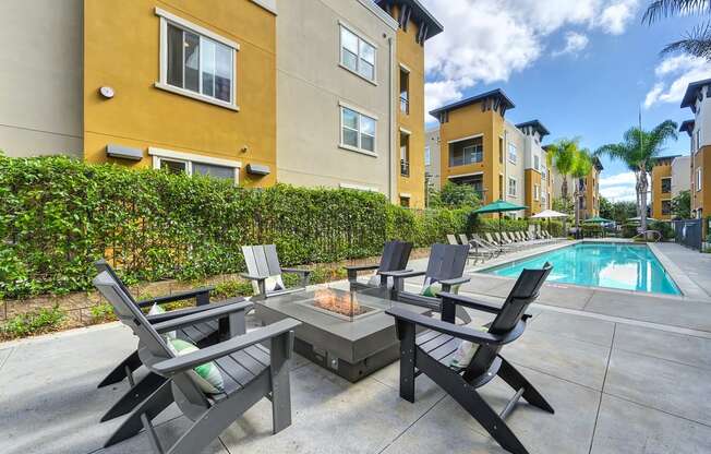 A patio with a table and chairs overlooking a pool.