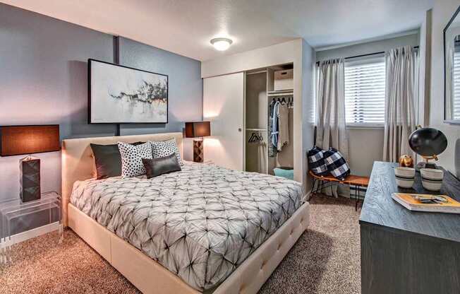 A bedroom with a large bed and a painting on the wall.