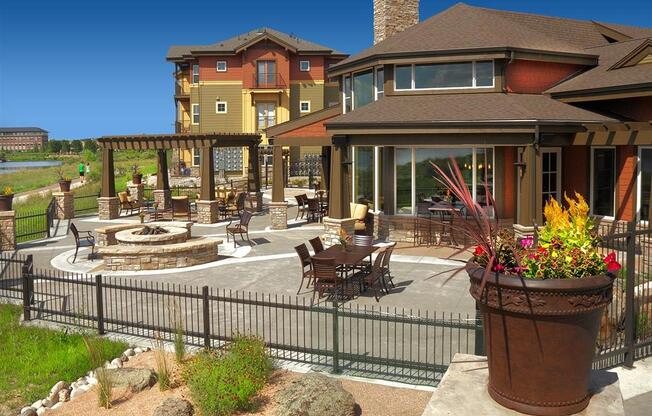 a patio with a fire pit and a large house