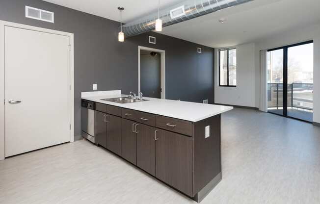 Modern open-concept kitchen and living area with stainless steel appliances.