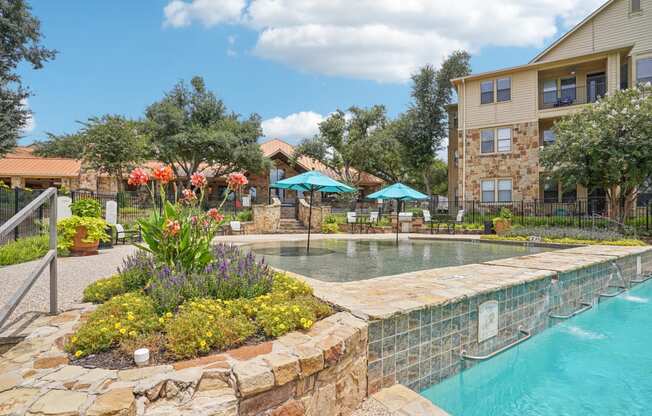 a swimming pool with a building in the background  at The Verandah, Austin, TX, 78726