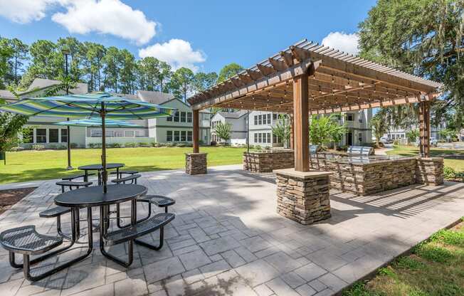 a picnic area with tables and umbrellas at the enclave at woodbridge apartments in sugar