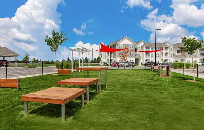 A park with benches and a building in the background.
