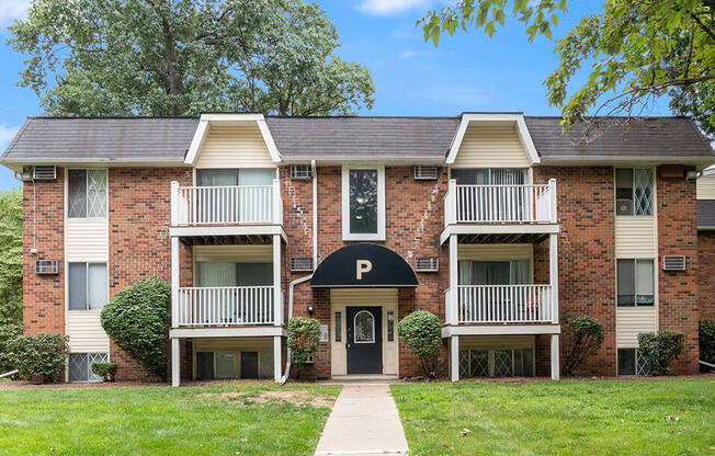 a red brick apartment building with a sidewalk in front of it