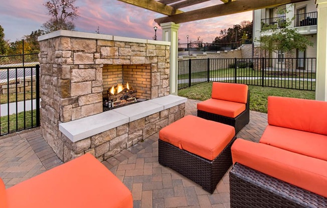 outdoor seating around a stone fireplace on a patio with orange furniture