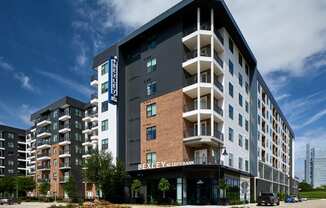 A modern multi-story building with a Bexley Apartments sign on the front.