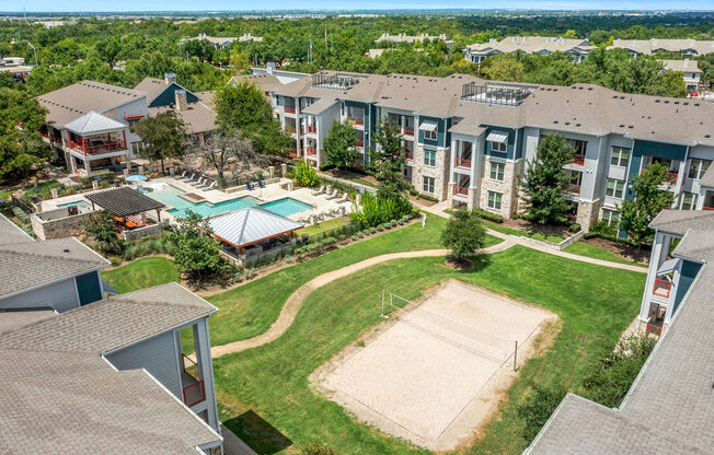 an aerial view of an apartment complex with a tennis court and a pool