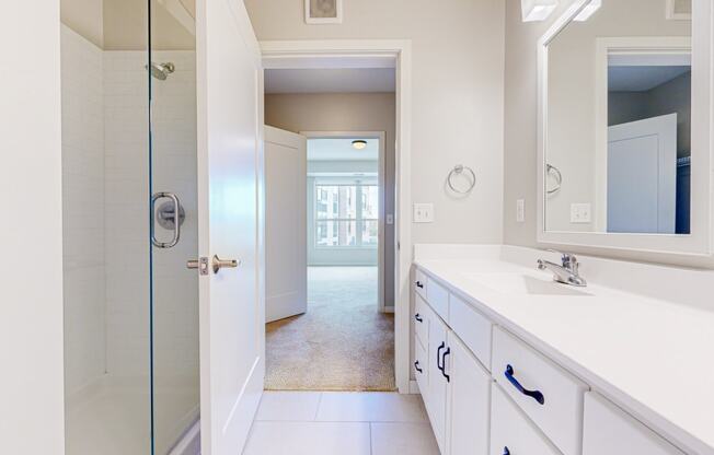 a bathroom with large vanity and glass standing shower