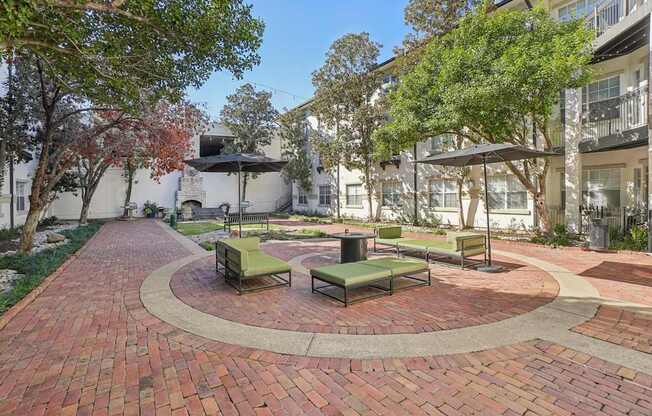 A courtyard with a circular brick patio and benches.