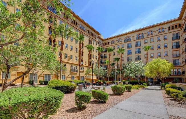 A sunny day at a courtyard with a building in the background.
