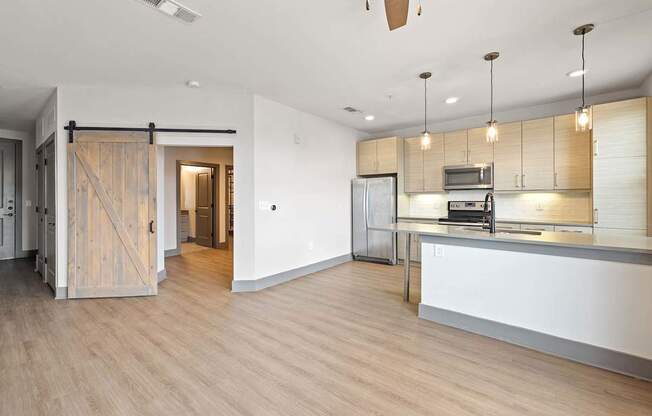 A kitchen area with a white counter and wooden floors.