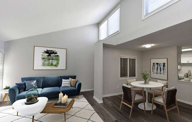 a living room with a blue couch and a dining room table