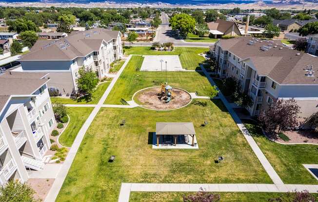 A large grassy area with a pavilion in the middle of apartment buildings.