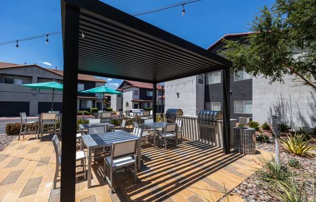 a covered patio with tables chairs and umbrellas at the enclave at woodbridge apartments in