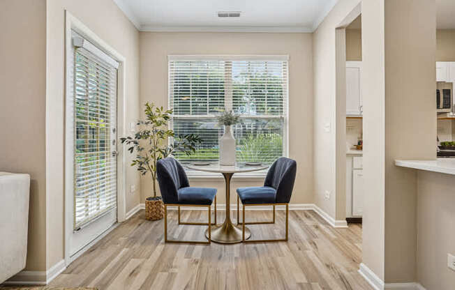 A room with a table and two chairs in the middle.