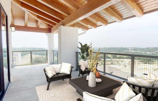 a living room with a table and chairs on a balcony