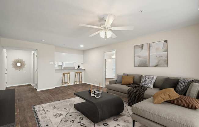 a living room with a couch and a ceiling fan at Woodlands of Plano in Plano, TX