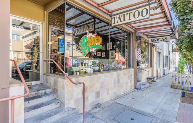 A tattoo shop with a red staircase leading to the entrance at Spyglass Hill Apartments, Bremerton, 98337
