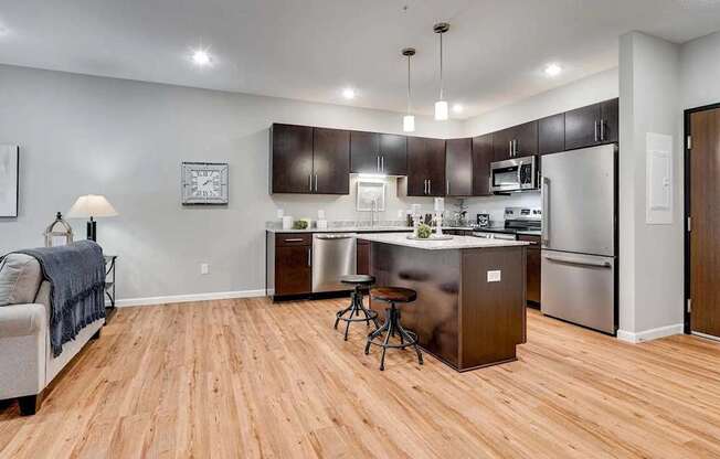 a kitchen with stainless steel appliances and a wooden floor. Circle Pines, MN Lexington Lofts