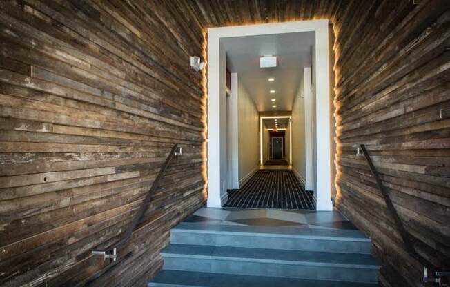 a hallway with wood paneling and a staircase