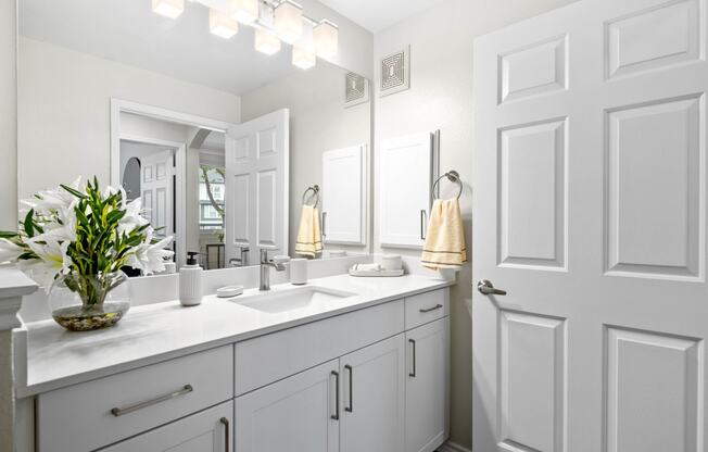 a white bathroom with two sinks and a mirror at Mission Gate, Plano