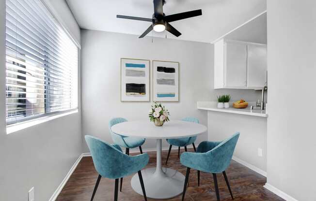 a dining room with a table and chairs and a ceiling fan