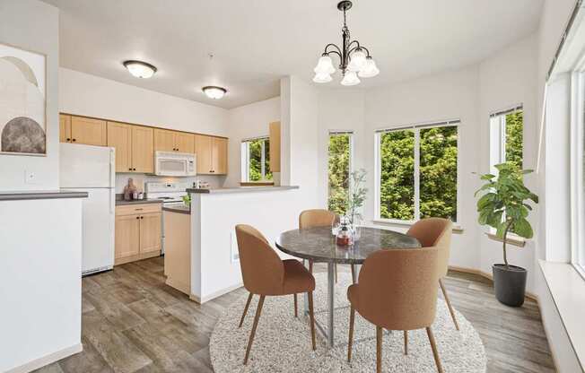 Virtually staged kitchen in the Jackson floor plan with a dining table at The Madison apartments in Olympia, WA