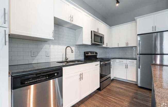 A kitchen with white cabinets and a black stove top.at Century Baxter Avenue, Louisville Kentucky