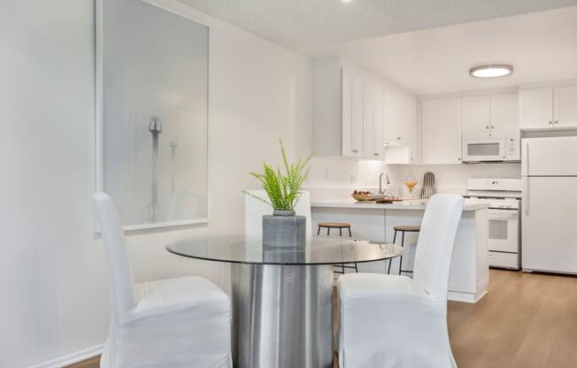 a dining room with white chairs and a table