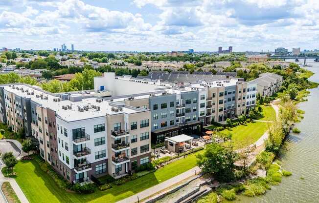 A large apartment complex sits on the edge of a river.