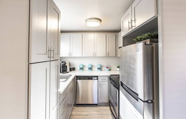 Kitchen in community lounge with stainless steel appliances and new white cabinets at The Lakes Apartments, Moses Lake, WA.