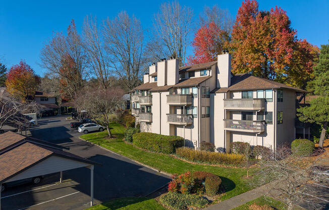 A large apartment complex with a parking lot in front.