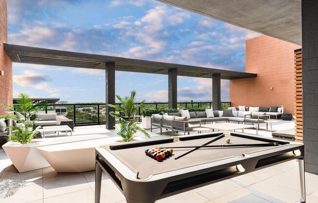 Sky lounge with billiards, sectional seating, and open-air views, creating a versatile setting for games, gatherings, and sunset conversations.