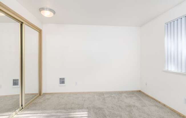 an empty room with a sliding glass door and a window