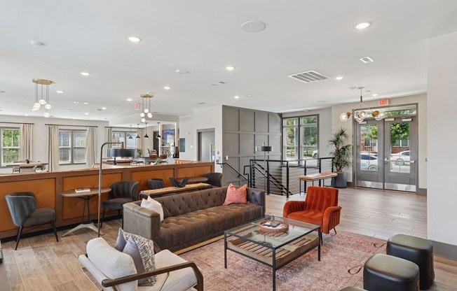 A modern living room with a brown couch and a glass coffee table.