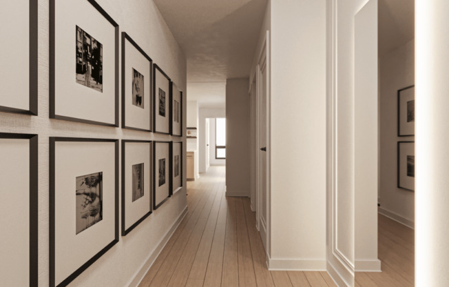a hallway with black and white photos on the wall and wooden floors at Chateau on Wells, Chicago, IL