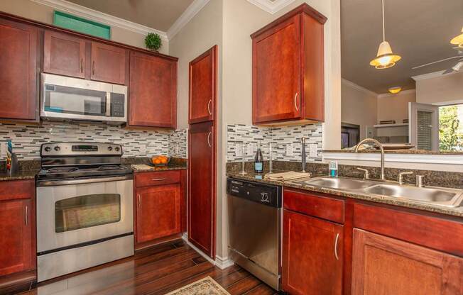 A kitchen with wooden cabinets and a stone backsplash.