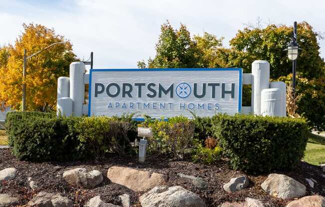 a sign forportrait apartment homes in front of trees and rocks