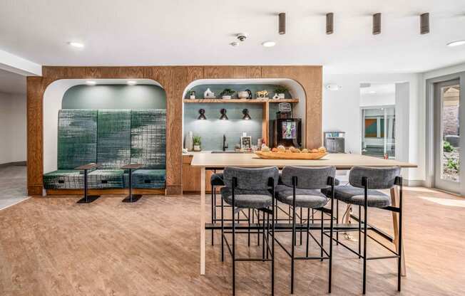 a bar with stools and a counter with chairs in a room with a kitchen