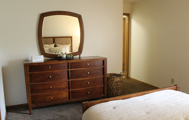 a bedroom with a dresser and a bed