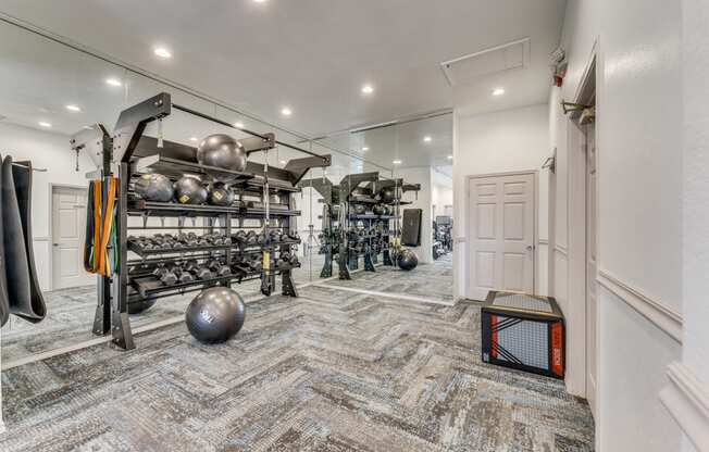 a workout room with weights and equipment and a door to a closet