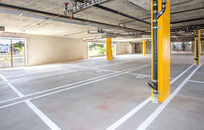 an empty parking lot with yellow poles in a building