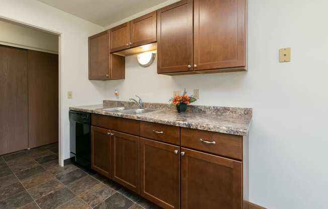 a kitchen with wooden cabinets and granite counter tops