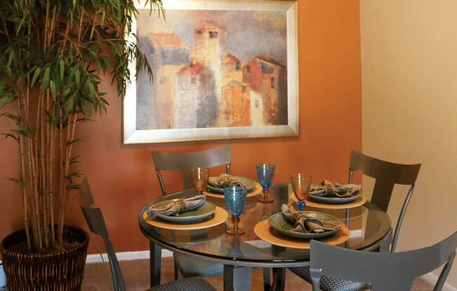 a dining room with a table and chairs and a painting on the wall