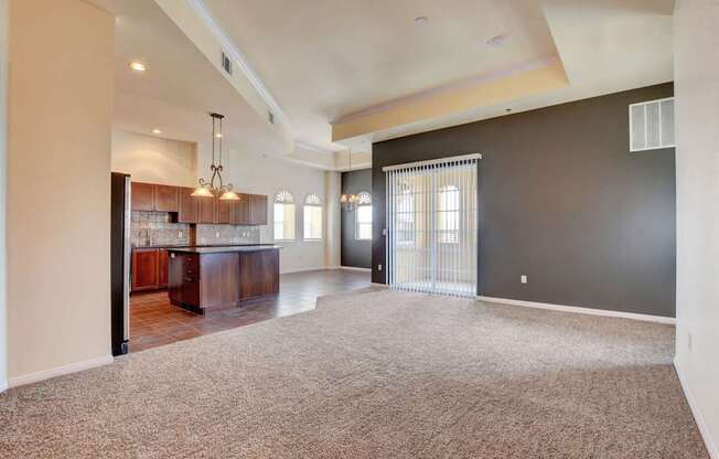 A spacious living room with a bar area and a carpeted floor.