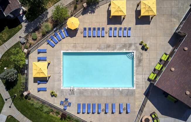 arial view of a swimming pool with blue and yellow umbrellas around it