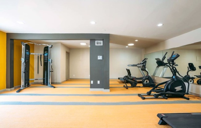 a workout room with weights and cardio equipment in a home gym